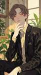 A softly lit interior, with a male model sitting in a thoughtful posture, dressed in a stylish black